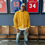 Allen Iverson standing in front of retired 76ers jerseys